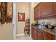 Stylish butler pantry with dark wood cabinets, granite countertops, and decorative shelving at 1112 Heron Point Way, Deland, FL 32724