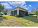 Back exterior of house with screened in patio and lush landscaping at 1112 Heron Point Way, Deland, FL 32724