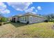 Exterior of home featuring a screened in patio and manicured lawn at 1112 Heron Point Way, Deland, FL 32724