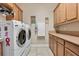 Functional laundry room featuring modern appliances, ample storage, and tile flooring at 1112 Heron Point Way, Deland, FL 32724