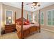 Spacious main bedroom with a four-poster bed, neutral walls, plantation shutters and carpet flooring at 1112 Heron Point Way, Deland, FL 32724