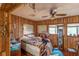 Wood-paneled bedroom with a ceiling fan, multiple windows, and personal items on display at 1221 Forest Cir, Altamonte Springs, FL 32714