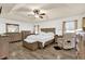 Spacious bedroom featuring a tray ceiling, wood-look floors, and ample furniture at 12991 Sw 72Nd Terrace Rd, Ocala, FL 34473