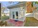 Exterior view of a quaint building with glass doors, set against a lush green lawn and privacy fence at 12991 Sw 72Nd Terrace Rd, Ocala, FL 34473