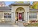 Inviting front entry with decorative glass door and arched entryway framed by stately columns at 12991 Sw 72Nd Terrace Rd, Ocala, FL 34473