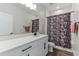 Bright bathroom features a modern vanity with black hardware, a large mirror, and fun superhero-themed shower curtain at 13819 Lanyard Way, Winter Garden, FL 34787