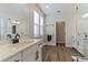 Stylish bathroom features a double vanity with black hardware and faucets, wood-look flooring, and lots of light at 13819 Lanyard Way, Winter Garden, FL 34787