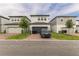 Well-manicured two-story home features modern architecture, a gray driveway, and lush green landscaping at 13819 Lanyard Way, Winter Garden, FL 34787