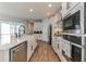 Well-equipped kitchen with stainless steel appliances, white cabinets, and modern fixtures at 13819 Lanyard Way, Winter Garden, FL 34787