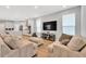 Open concept living area with wood floors, neutral colors, and a seamless flow into the modern, white kitchen at 13819 Lanyard Way, Winter Garden, FL 34787