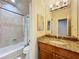 Bathroom featuring granite counters, tiled shower, vanity lighting, and vanity mirror at 1502 Hempel Ave, Windermere, FL 34786