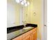 Bathroom vanity featuring a dark granite countertop and a light wood cabinet with a modern sink and faucet at 1502 Hempel Ave, Windermere, FL 34786