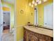 The bathroom with golden walls has a decorative light fixture and a unique vanity design at 1502 Hempel Ave, Windermere, FL 34786