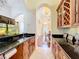 Open butler's pantry featuring dark granite counters, wooden cabinetry, and clear view of the dining room at 1502 Hempel Ave, Windermere, FL 34786