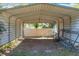 Open metal carport with a dirt floor, and a messy collection of discarded fencing and debris at 1502 Hempel Ave, Windermere, FL 34786