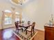 Sunlit dining room with decorative windows, chandelier, and rich hardwood floors at 1502 Hempel Ave, Windermere, FL 34786