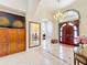 Grand foyer featuring high ceilings, tiled floors, decorative mirror, and a wooden front door at 1502 Hempel Ave, Windermere, FL 34786