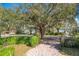 Lush, green landscaping with a mature tree and charming brick walkway at 1502 Hempel Ave, Windermere, FL 34786