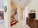 Bright hallway with tile floors, staircase, and media cabinet enhances the home's appeal at 1502 Hempel Ave, Windermere, FL 34786