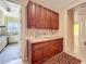 Well-lit laundry room with wooden cabinets, granite countertops and a sink, plus appliances at 1502 Hempel Ave, Windermere, FL 34786