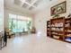 Large living room features tile flooring, built-in shelving, and large windows overlooking a screened-in pool at 1502 Hempel Ave, Windermere, FL 34786