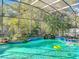 A private screened pool with tropical plants and a waterfall feature for an at-home oasis at 1502 Hempel Ave, Windermere, FL 34786