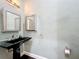 Contemporary powder room with black pedestal sink, modern fixtures, and stylish vanity mirror at 1502 Hempel Ave, Windermere, FL 34786