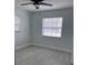 This bedroom has light gray flooring, pale blue walls, and a ceiling fan with a light at 15081 Sw 35Th Cir, Ocala, FL 34473