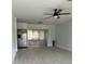 Open-concept room with ceiling fan, modern stainless fridge, and gray vinyl flooring at 15081 Sw 35Th Cir, Ocala, FL 34473