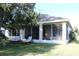 View of the backyard, screened-in porch, and landscaping from the grass yard at 1746 Golfview Drive, Kissimmee, FL 34746