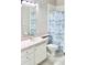 Clean bathroom with a white vanity, toilet, and blue patterned shower curtain at 1746 Golfview Drive, Kissimmee, FL 34746