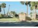 Community directional sign at entrance with lush greenery and palm trees, showcasing the neighborhood's amenities and serene location at 1746 Golfview Drive, Kissimmee, FL 34746