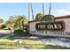 Entrance sign to The Oaks Golf Club & Community with lush landscaping and mature trees in a serene setting at 1746 Golfview Drive, Kissimmee, FL 34746