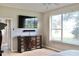 Main bedroom with a large dresser, mounted TV, and a window overlooking the garden at 1746 Golfview Drive, Kissimmee, FL 34746