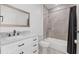 Modern bathroom with white vanity, marble countertop, framed mirror, and tiled shower/tub combo with a shower curtain at 1751 Sereno Dr, Davenport, FL 33896