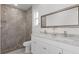 Modern bathroom featuring a double vanity with marble countertop and a walk-in shower with gray tile surround at 1751 Sereno Dr, Davenport, FL 33896