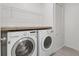 Convenient laundry room featuring a full-size washer and dryer set with overhead shelving at 1751 Sereno Dr, Davenport, FL 33896