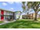 View of the apartment complex with mature trees and lawn at 1897 Caralee Blvd # 2, Orlando, FL 32822