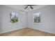 Bright bedroom featuring a ceiling fan, AC unit, new windows, neutral walls, and wood-look flooring at 19 N Van Buren Ave, Orlando, FL 32811