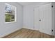 Inviting bedroom with wood-look flooring, a window, and a white door with modern hardware at 19 N Van Buren Ave, Orlando, FL 32811