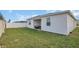 Large grassy backyard features a white fence and a covered patio at 1934 Pond Pine Ct, Haines City, FL 33844