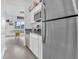 Modern kitchenette with stainless steel refrigerator and sink, white cabinets, and gray tile flooring at 1934 Pond Pine Ct, Haines City, FL 33844