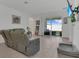 Well-lit living room boasting comfortable seating, tile floors, and sliding glass doors to the patio at 1934 Pond Pine Ct, Haines City, FL 33844