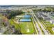 An aerial view shows tennis and soccer courts and a lush greenbelt in a residential neighborhood at 1982 Cricket Cradle Dr, Kissimmee, FL 34746