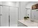 Bathroom featuring tiled shower, glass doors, a white vanity, and chrome fixtures at 1982 Cricket Cradle Dr, Kissimmee, FL 34746