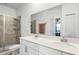 Bright bathroom featuring a double sink vanity with white cabinets and a glass-enclosed tiled shower at 1982 Cricket Cradle Dr, Kissimmee, FL 34746