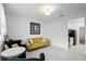 Bright living room featuring tiled flooring, a yellow sofa, and doorway to kitchen and dining area at 1982 Cricket Cradle Dr, Kissimmee, FL 34746