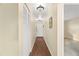 Long hallway with hardwood floors leading to the front door, featuring a closet and neutral paint at 200 El Camino Dr # 402, Winter Haven, FL 33884