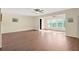 Spacious living room featuring hardwood floors and multiple windows for natural light at 200 El Camino Dr # 402, Winter Haven, FL 33884