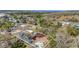 An aerial view of a property featuring multiple buildings, surrounded by trees, with a lake and fields in the background at 204 Brooks Rd, Frostproof, FL 33843